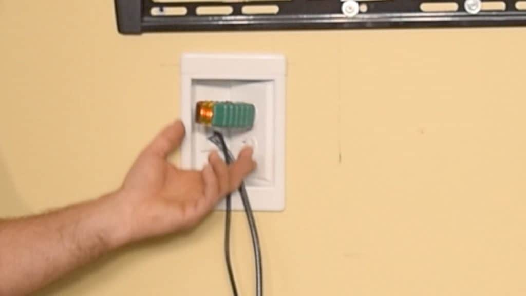 Testing that an outlet has power by using a plug tester.