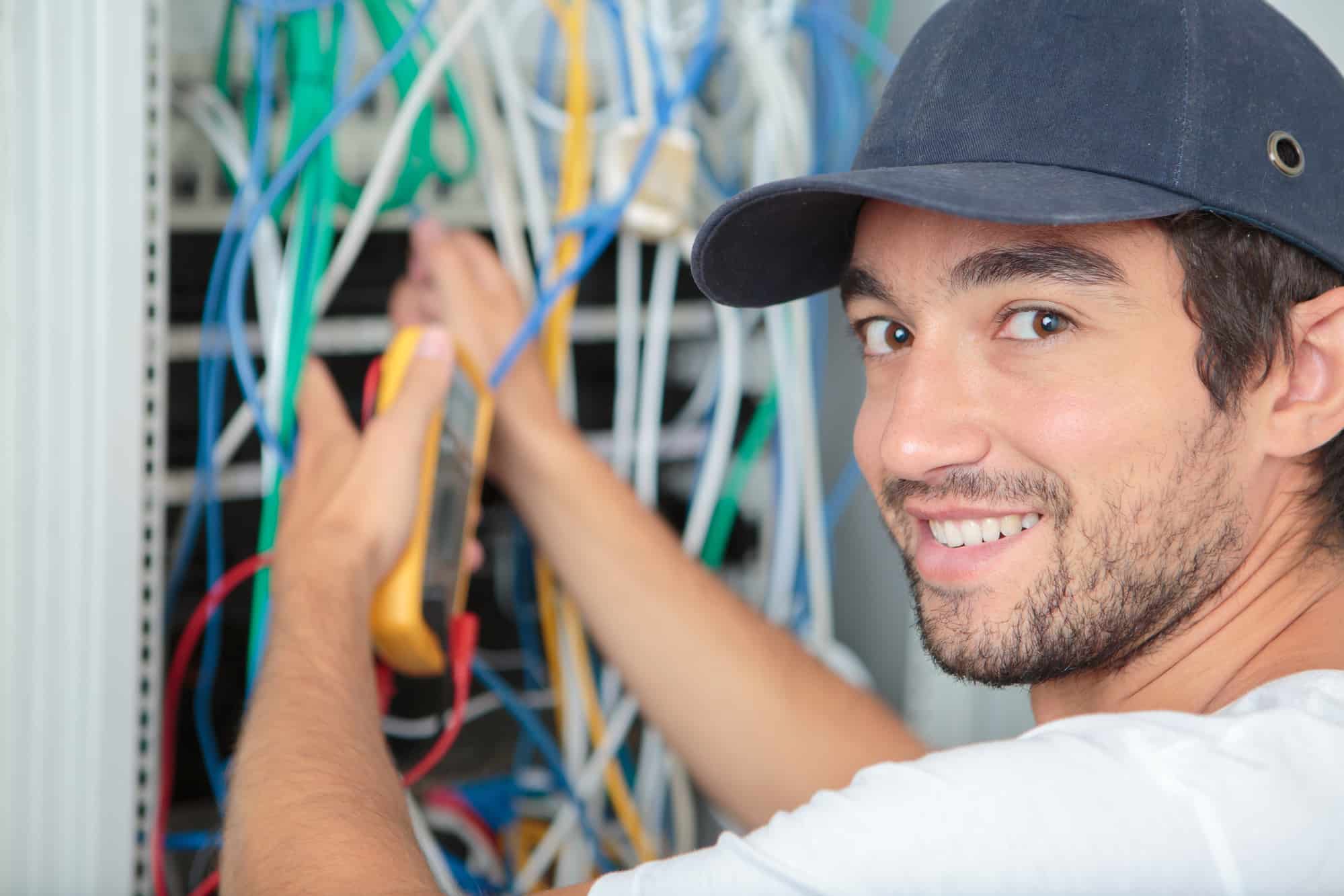 smiling electrician working on wires
